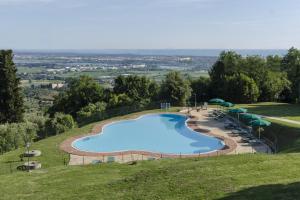 una grande piscina su una collina con ombrelloni di Frantoio di Corsanico a Corsanico-Bargecchia