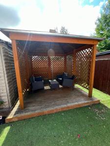 a wooden gazebo with couches on a deck at Entire Modern House in Staffordshire 