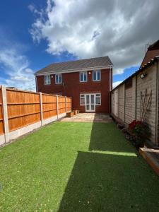 a house with a large yard with a fence at Entire Modern House in Staffordshire 