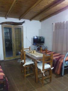 a room with a table and a bed and a television at Cabaña en el lago in Trapiche