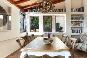 a dining room with a wooden table and some windows at Villa Zinnia in Skiathos