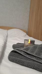 a candle sitting on top of a bed with towels at Къща под наем-нощувки in Targovishte