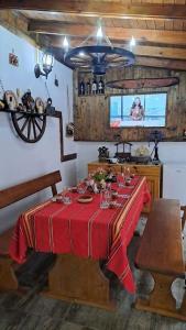 a dining room with a table with a red table cloth at Къща под наем-нощувки in Targovishte
