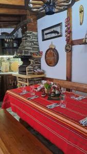 uma mesa com uma toalha de mesa vermelha e um fogão em Къща под наем-нощувки em Targovishte