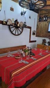 a table with a red table cloth and a wheel at Къща под наем-нощувки in Targovishte