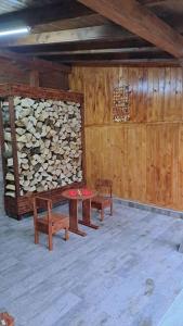 a room with benches and a table and a pile of logs at Къща под наем-нощувки in Targovishte