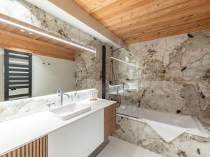 LʼHuezにあるChalet de luxe, spa, ski aux pieds, Alpe d'Huez - FR-1-645-48の洗面台と浴槽のあるバスルーム