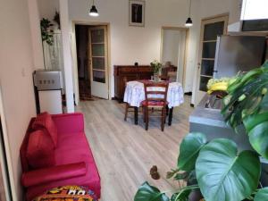 uma sala de estar com uma mesa e um sofá rosa em Bologna centro em Bolonha