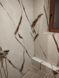 a bathroom with a shower with a marble wall at Ekali stone house in Kaléntzion