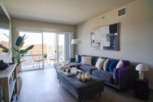 Blue Marina Views Top Floor Unit 2BD 2BA في لوس أنجلوس: غرفة معيشة مع أريكة زرقاء وطاولة