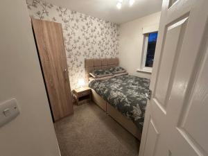 a small bedroom with a bed and a window at Entire Modern House in Staffordshire 