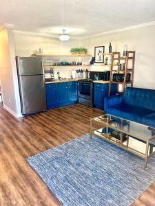a living room with a blue couch and a kitchen at Indigo DowntownWalkable KingBed in Raleigh