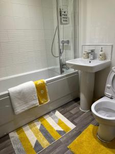 a bathroom with a sink and a toilet and a shower at Munalux 2 bed in Birmingham