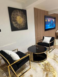 a living room with two chairs and a table at Sweet and Spa in Marly-la-Ville
