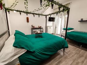 a bedroom with a bed with a green blanket at Afrodite Guest House in Caserta