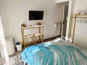 um quarto com uma cama e dois bancos e uma televisão em Afrodite Guest House em Caserta