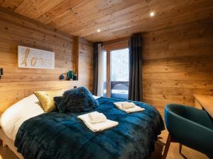ein Schlafzimmer mit einem Bett mit zwei Handtüchern darauf in der Unterkunft Duplex 4★ 8 pers, 60m des pistes, 4 ch, élégance à La Clusaz - FR-1-304-284 in La Clusaz