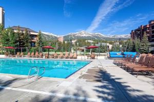 uma piscina com cadeiras e montanhas ao fundo em Hyatt Main Street Station, steps to Peak 9 & downtown em Breckenridge