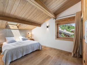 Un dormitorio con una cama grande y una ventana en Chalet Megève, 6 pièces, 9 personnes - FR-1-569-140, en Megève