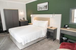 a bedroom with a white bed and green walls at Park Inn by Radisson Bournemouth in Bournemouth
