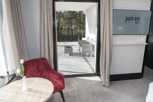 a room with a table and a chair and a mirror at Park Inn by Radisson Bournemouth in Bournemouth