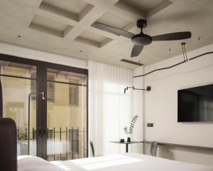 una camera da letto con ventilatore a soffitto e finestra di Pleiades Urban Stay by Semavi a Heraklion