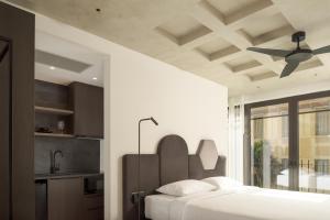 una camera con letto e ventilatore a soffitto di Pleiades Urban Stay by Semavi a Heraklion