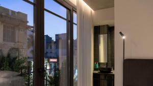 een kamer met een raam met uitzicht op de stad bij Pleiades Urban Stay by Semavi in Heraklion