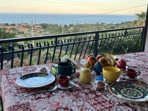 - une table avec des assiettes de nourriture sur le balcon dans l'établissement Case vacanze Villa La Terrazza Sul Mare a Trabia, à Trabia