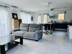 a living room with a couch and a table at Maison familiale au cœur d'Hasparren, 2 chambres, 2 salles d'eau, jardin clôturé, animaux acceptés - FR-1-495-131 in Hasparren