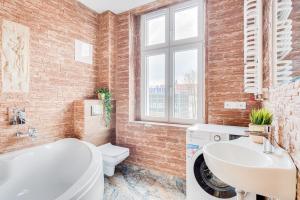 a bathroom with a white tub and a sink at Hann Haven Apartments Ozimska 55 in Opole