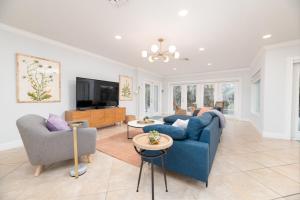 sala de estar con sofá azul y TV en Luxurious Fort Lauderdale Pool Home en Fort Lauderdale