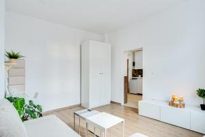 a white living room with a white couch and tables at Hann Haven Apartments Ozimska 55 in Opole