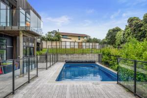 a swimming pool in the backyard of a house at Sun and Serenity - Waikanae Beach Holiday Home in Waikanae