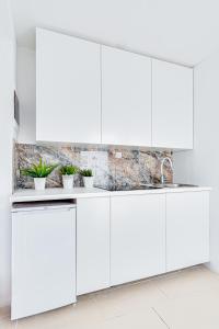 a white kitchen with white cabinets at Hann Haven Apartments Ozimska 55 in Opole