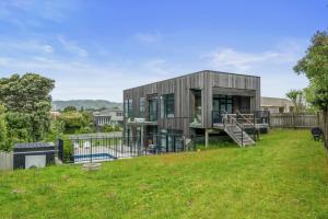 a small wooden house with a yard at Sun and Serenity - Waikanae Beach Holiday Home in Waikanae