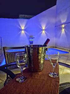 un cubo y dos copas de vino en una mesa en Piscina Aquecida, Ar condicionado Casa Inteira,Caminhos da Canastra, en São João Batista do Glória