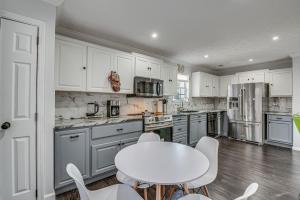 a kitchen with white cabinets and a white table and chairs at College Park Home 13 Mi to Downtown Atlanta! in College Park