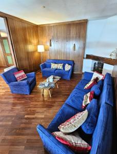 un soggiorno con divani blu e un divano blu di Cervino 1865 - Family House a Breuil-Cervinia