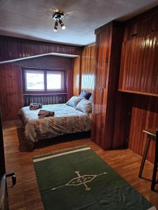 a bedroom with a bed and a green rug at Cervino 1865 - Family House in Breuil-Cervinia