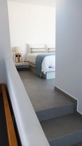 a bedroom with a bed and a stairway leading to it at Aeifos Boutique Hotel in Imerovigli