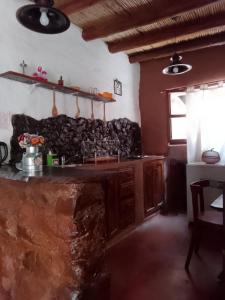cocina con encimera de piedra en una habitación en La Amanecida Tilcara Departamento tipo estudio en Tilcara