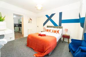 a bedroom with a bed and a blue and white wall at Bright Medway studio flat opposite Chatham station in Chatham
