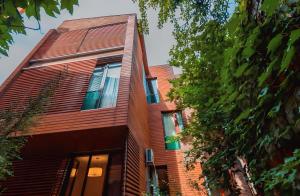 a red brick building with windows and trees at Cabernet Corner in Tbilisi City