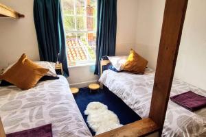 a white dog laying between two beds in a room at Bramblewick Cottage in Robin Hood's Bay