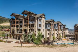 a large apartment building with a pool in front of it at Silverado Lodge by All Seasons Resort Lodging in Park City