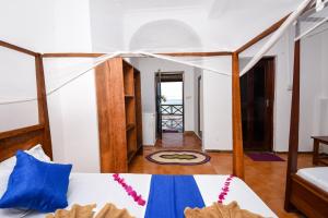 1 dormitorio con 1 cama con almohadas azules en Blue Tides Hotel, en Nungwi