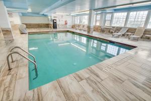 een groot zwembad in een gebouw met stoelen bij Quality Inn & Suites Galveston - Beachfront in Galveston