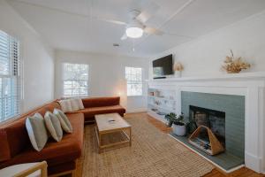 a living room with a couch and a fireplace at The Bungalow Loft by WB Abodes in Wrightsville Beach