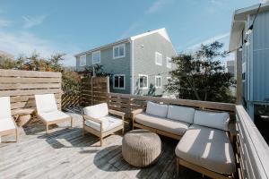 un patio con sofá y sillas en una terraza en The Bungalow Loft by WB Abodes, en Wrightsville Beach